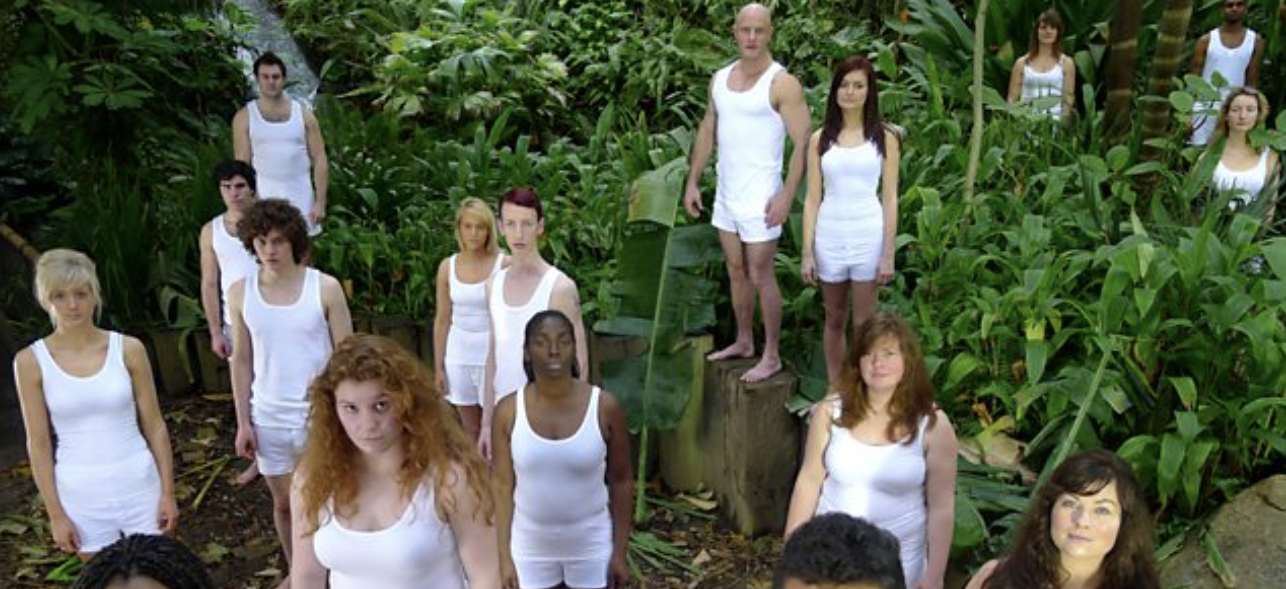 People wearing white standing in a forest