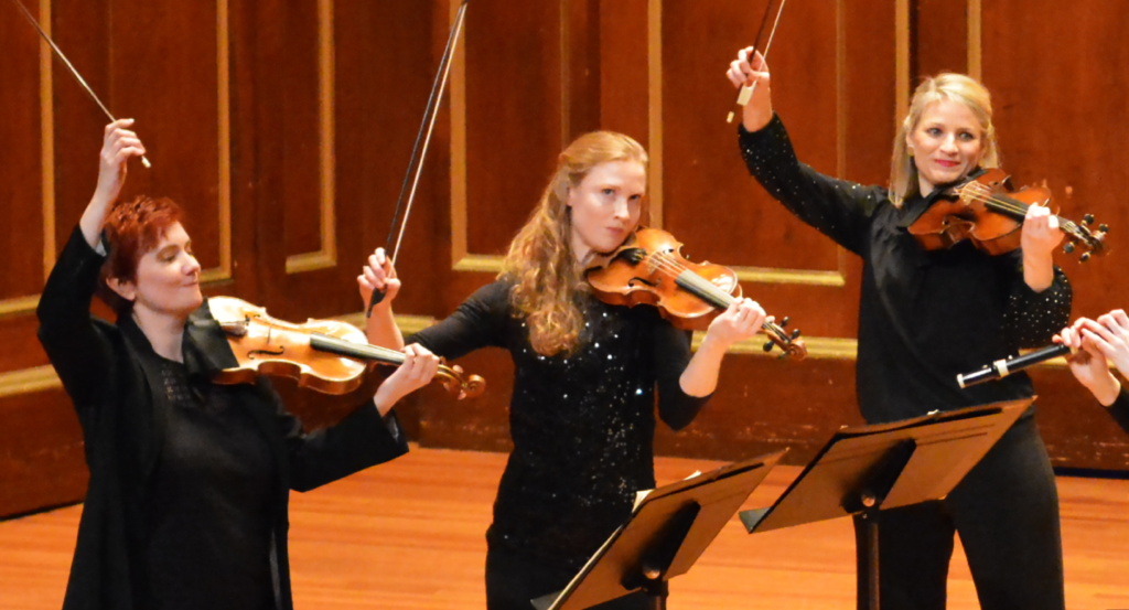 three woman playing the violin